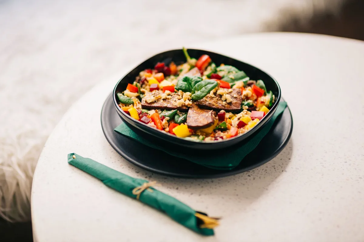 Bol coloré avec légumes grillés, céréales et roquette fraîche