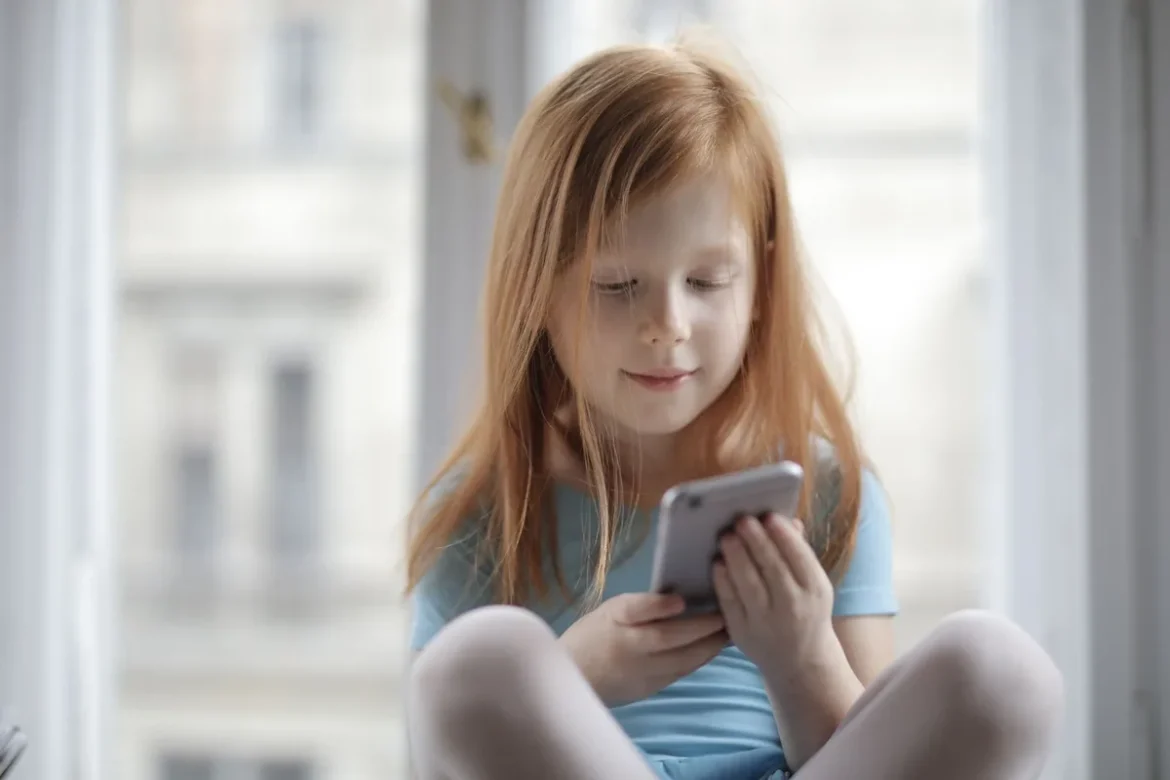 Enfant seul à la maison avec téléphone accessible et environnement sécurisé.