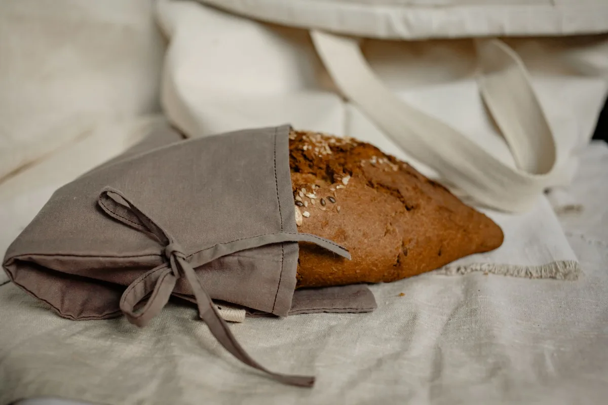 Pain enveloppé dans un torchon en coton avant rangement dans une boîte aérée