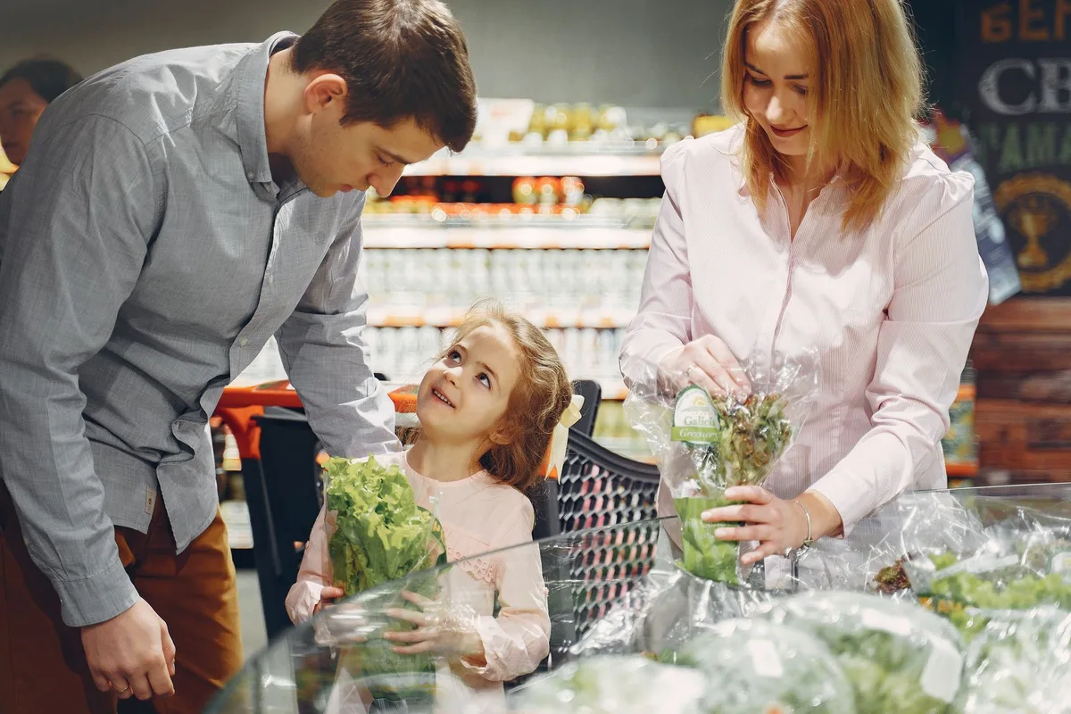 Parent écoutant attentivement un enfant dans un endroit calme du supermarché.