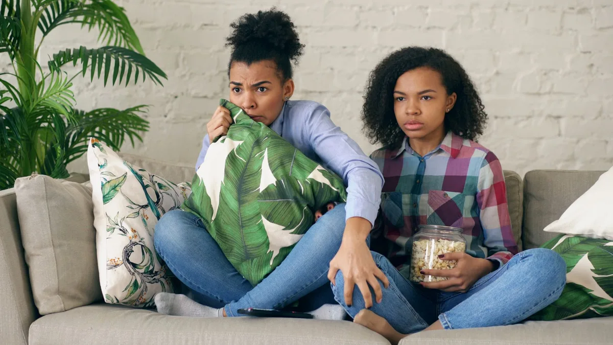 Adolescent absorbé par la projection d'un film, exprimant une émotion sincère.