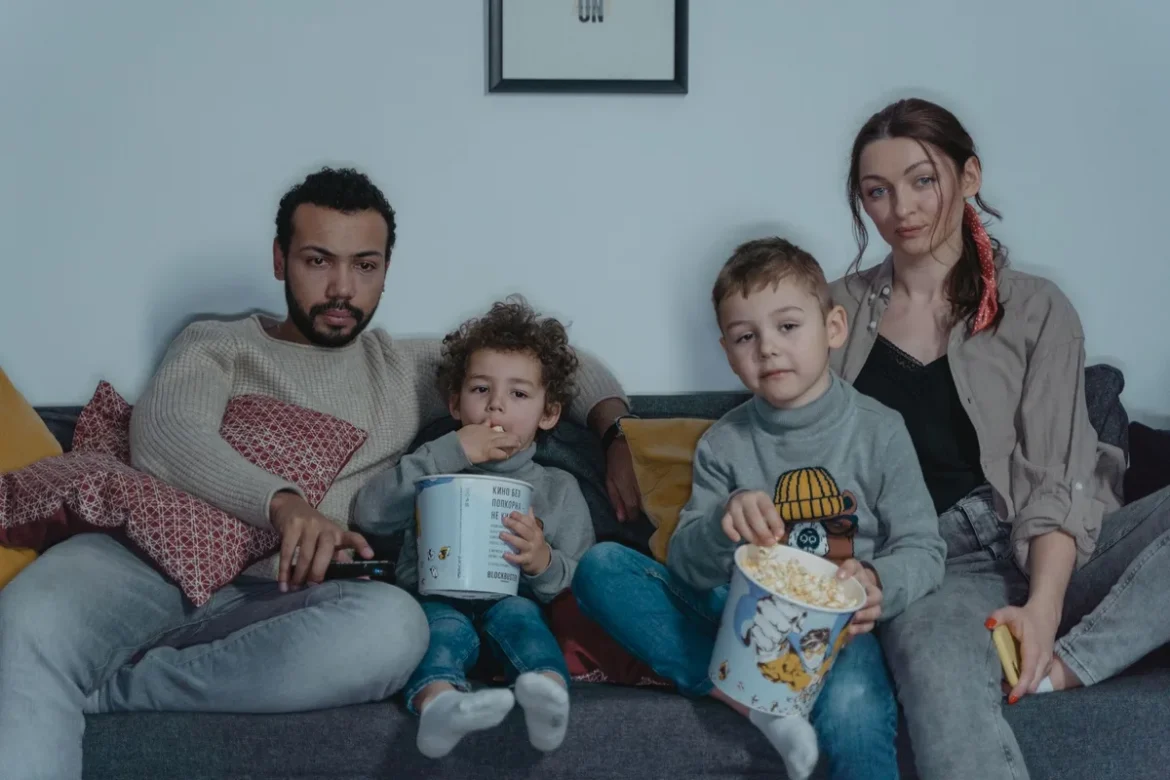 Famille regardant un film ensemble sur le canapé dans un salon confortable.