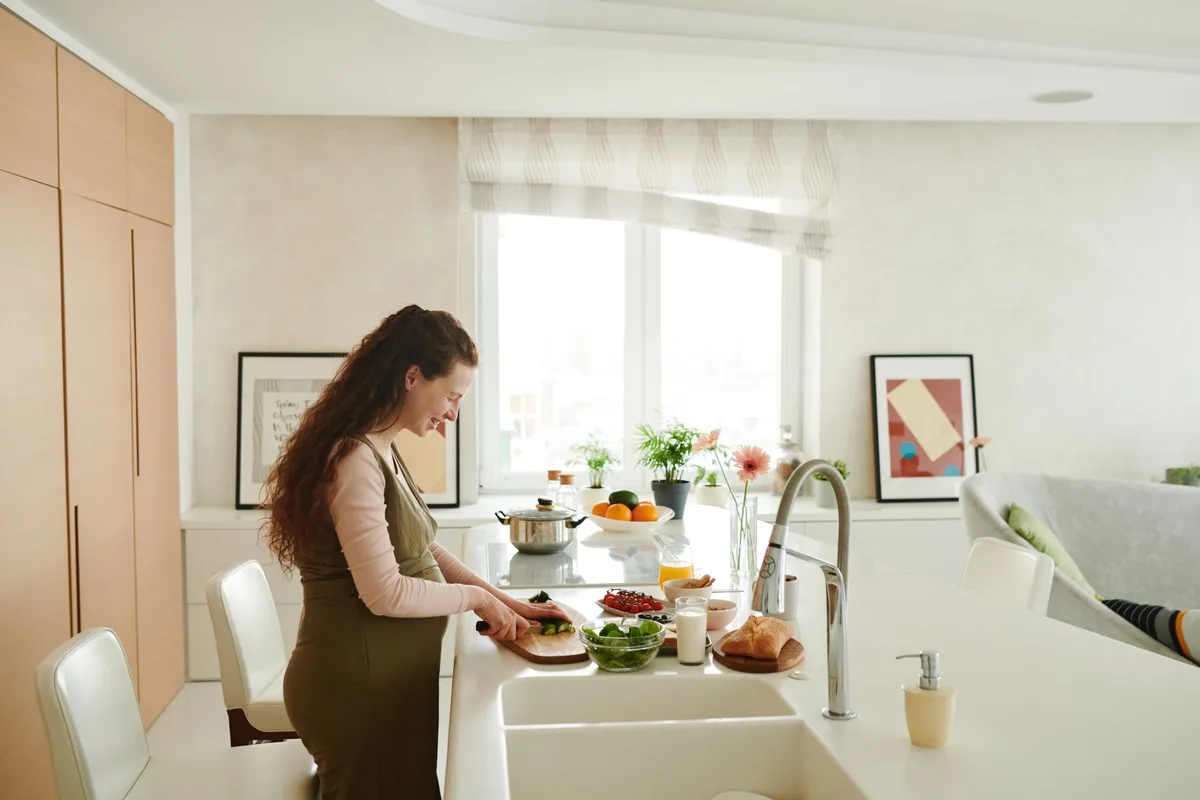 Femme enceinte préparant un repas équilibré avec des légumes frais et des protéines