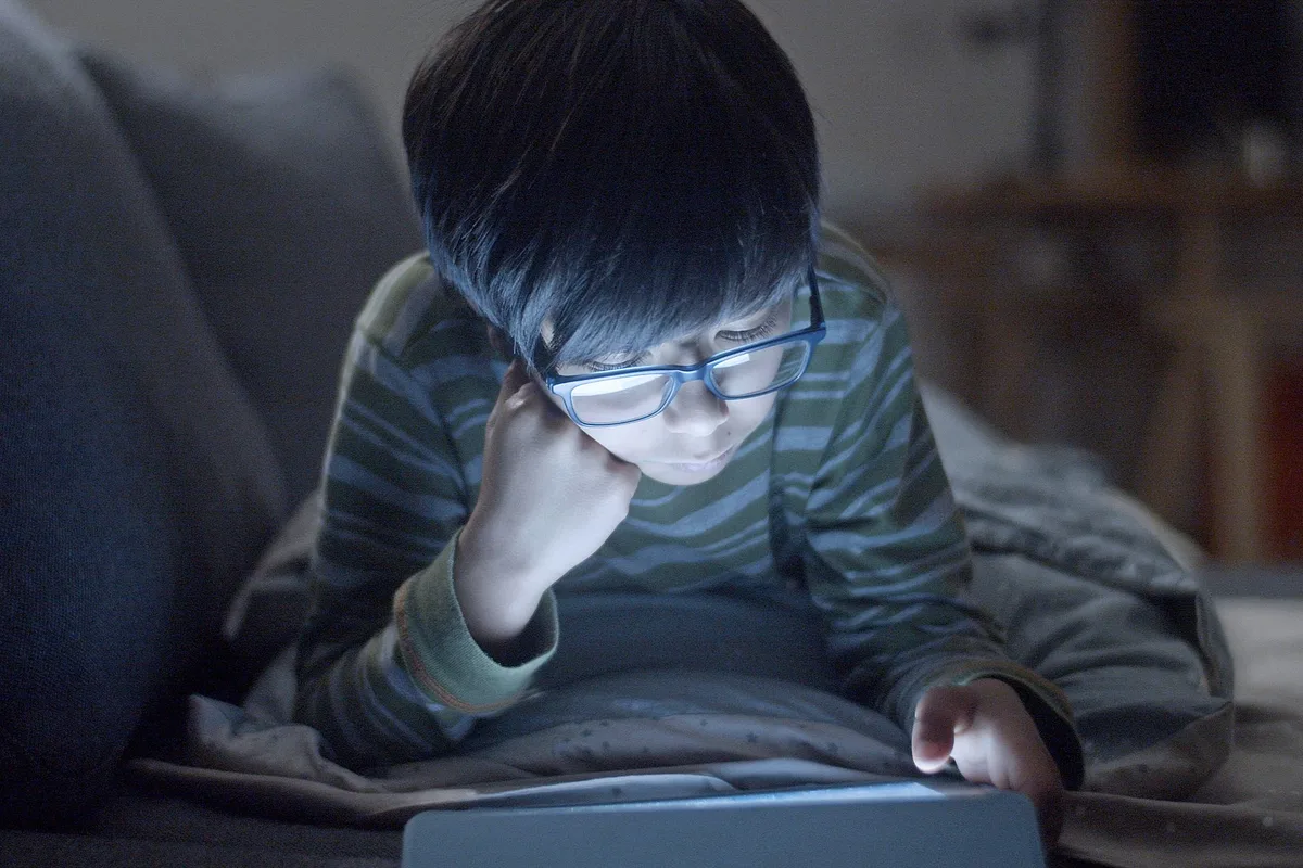 Enfant utilisant une tablette ou un smartphone, illustration des enjeux d'écrans à la maison.