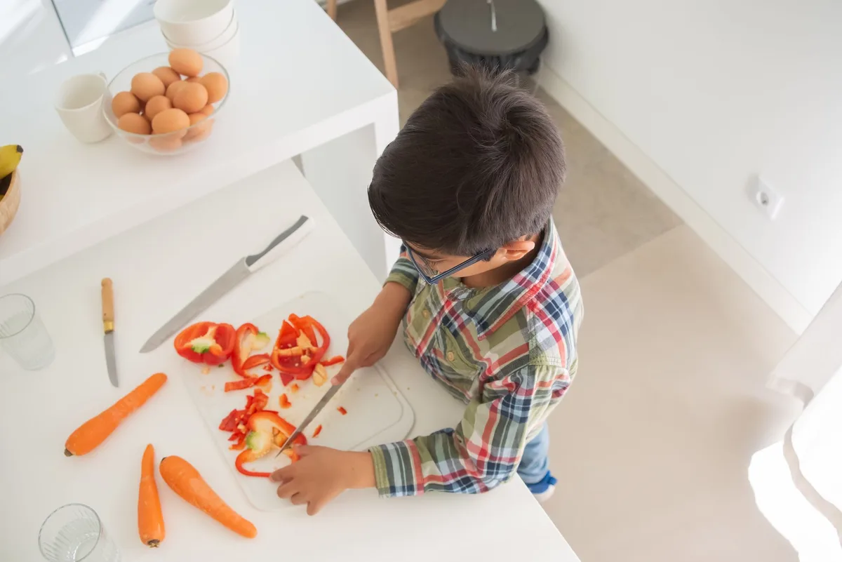 Enfant apprenant à manipuler un couteau avec les bonnes techniques de sécurité.