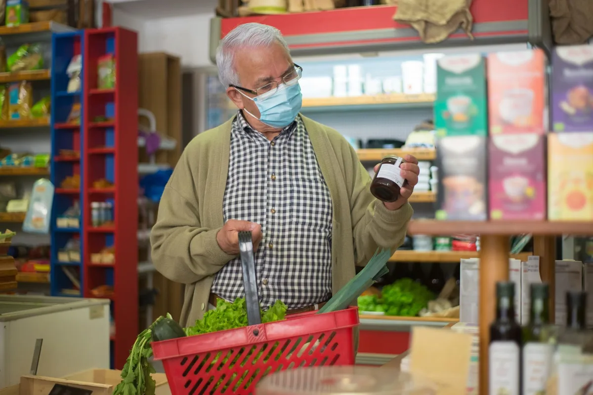 Personne lisant attentivement l'étiquette nutritionnelle d'un produit alimentaire