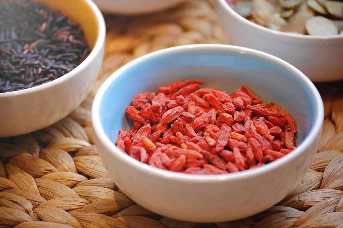 Différentes formes de baies de goji : baies séchées, poudre, jus et mélange pour infusion en magasin.