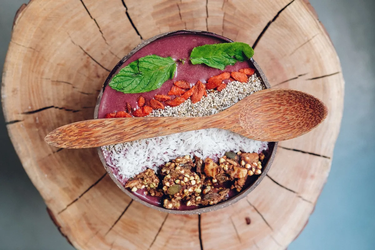 Bol de petit-déjeuner garni de goji berries, muesli et yaourt blanc.