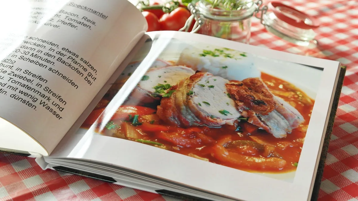 Livres de cuisine pratique ouverts sur un plan de travail avec des ingrédients.
