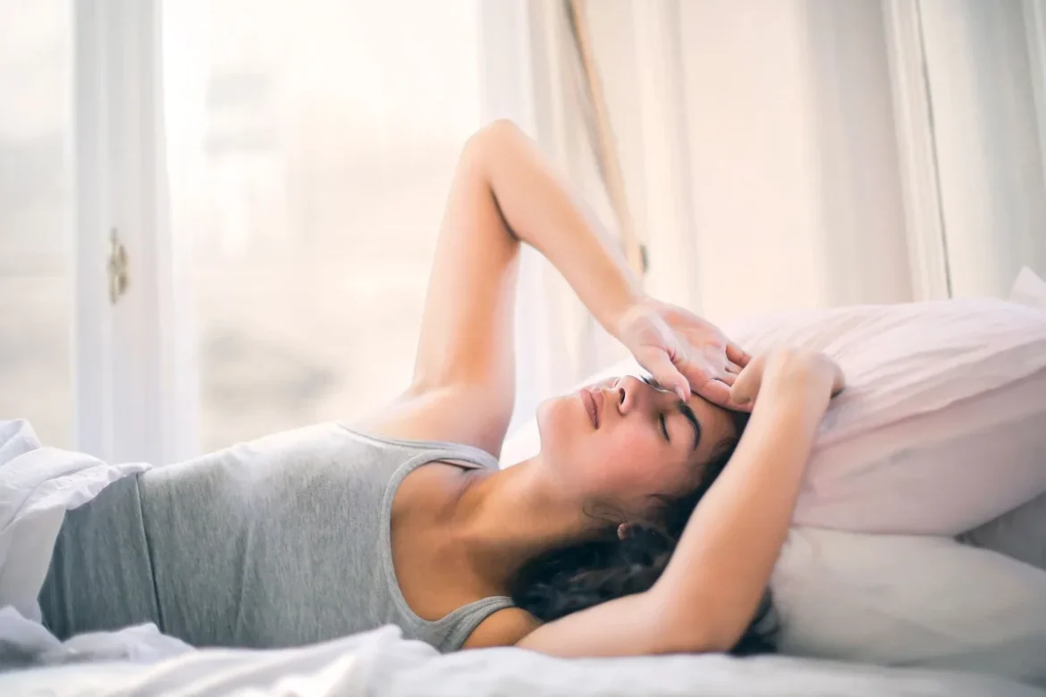 Personne se réveillant le matin avec une douleur à la mâchoire, main touchant la zone douloureuse