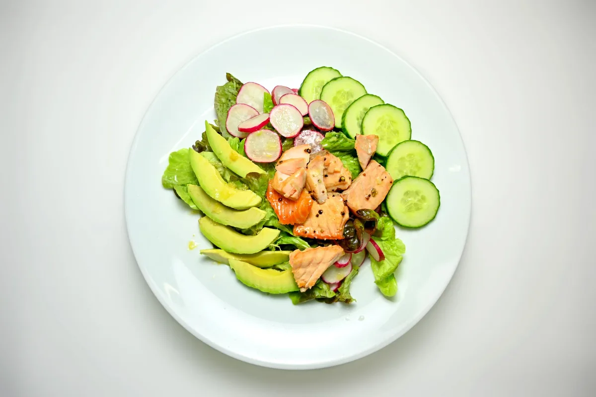 Assiette de salade tiède avec filet de saumon et légumes variés