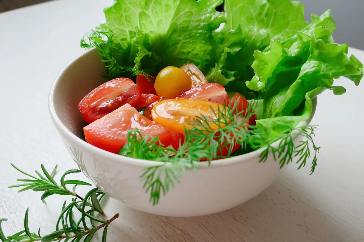 Légumes frais - roquette, tomates cerises et épinards pour enrichir le plat