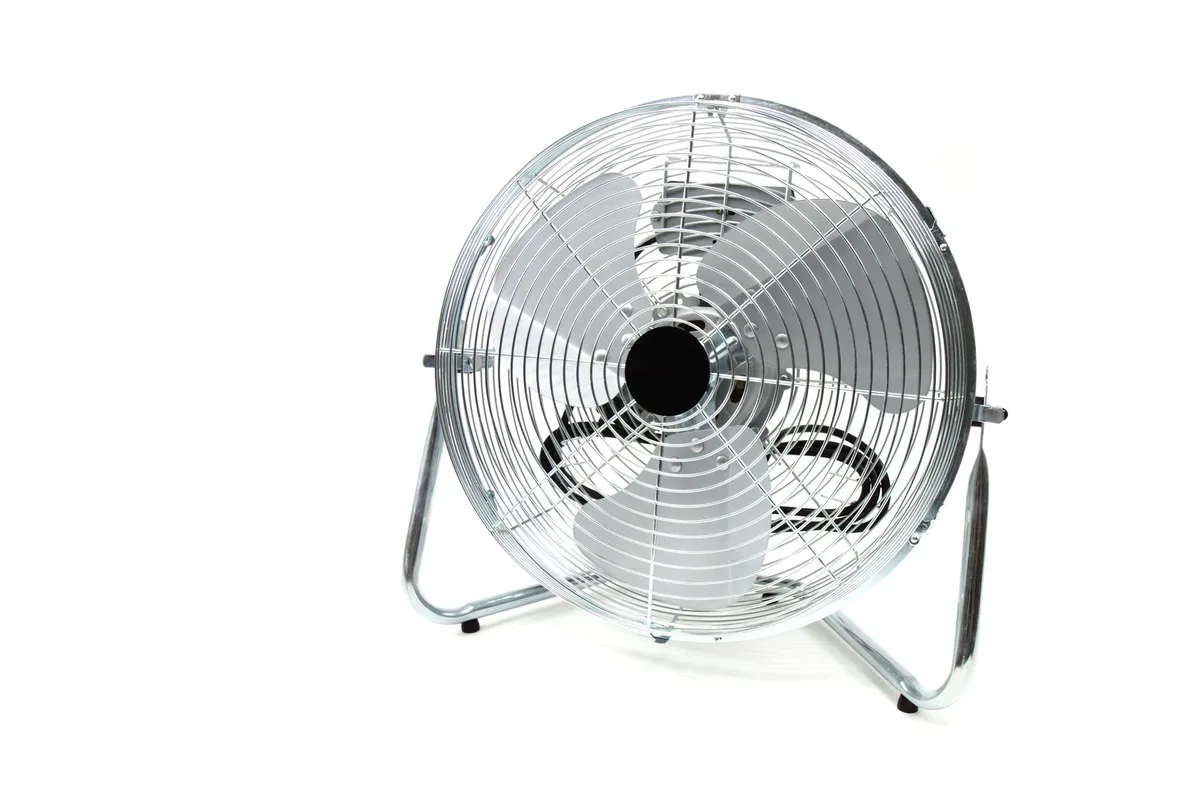 Ventilateur positionné à la fenêtre pour créer une circulation d'air frais dans la chambre