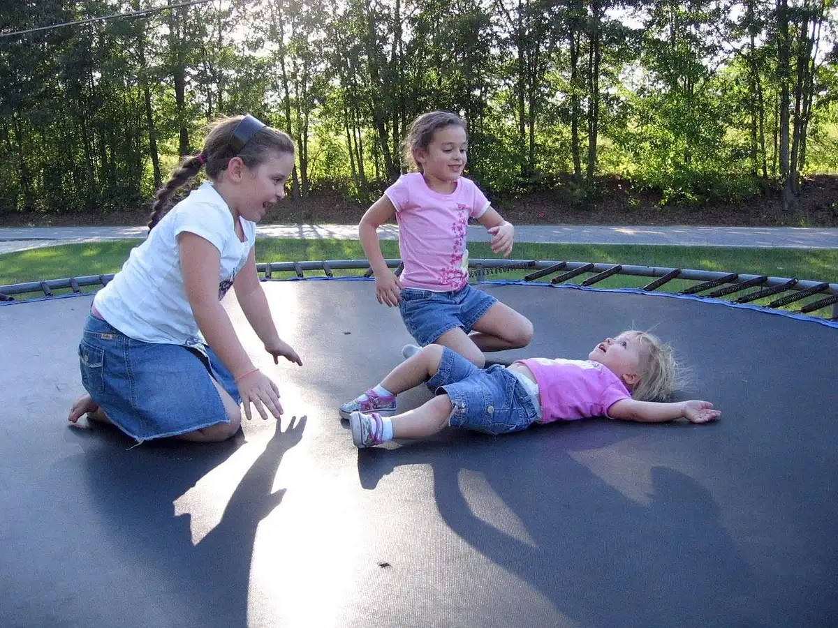 Différentes tailles de trampolines posés dans un jardin montrant comparaison de diamètres