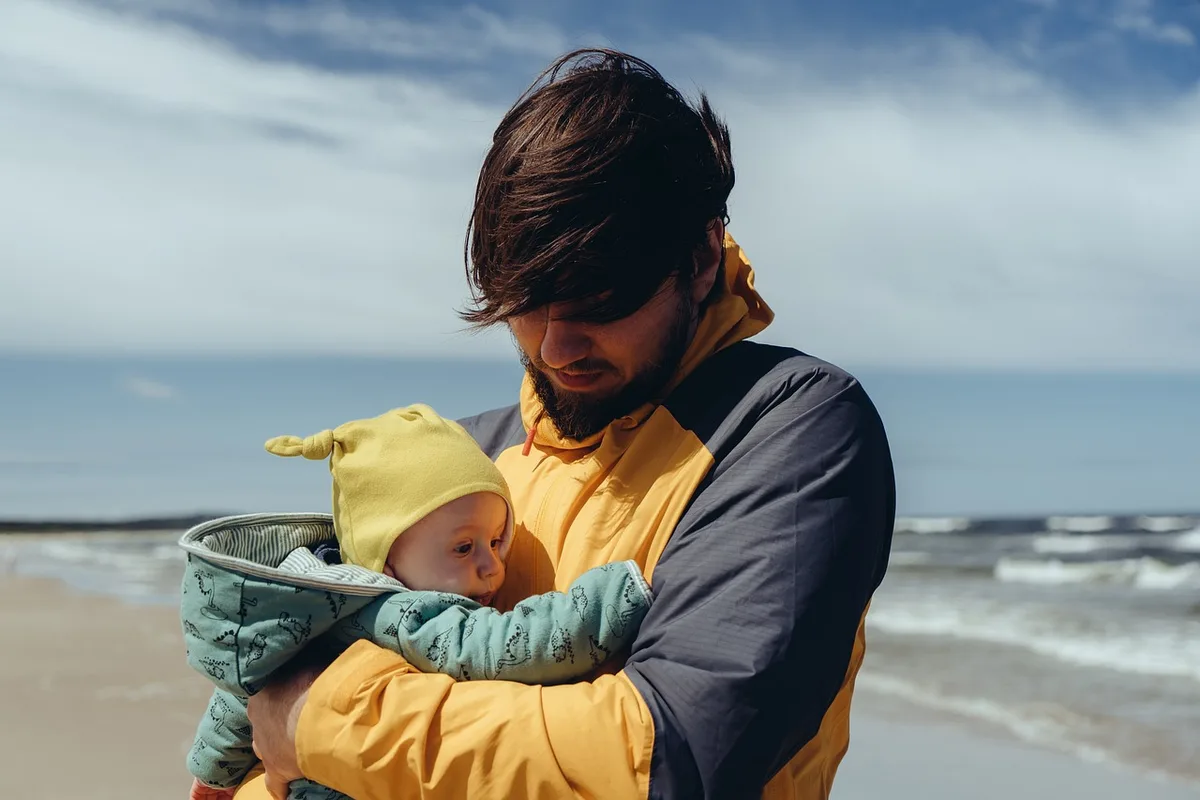 Parent et enfant lisant ensemble près d'une fenêtre en journée