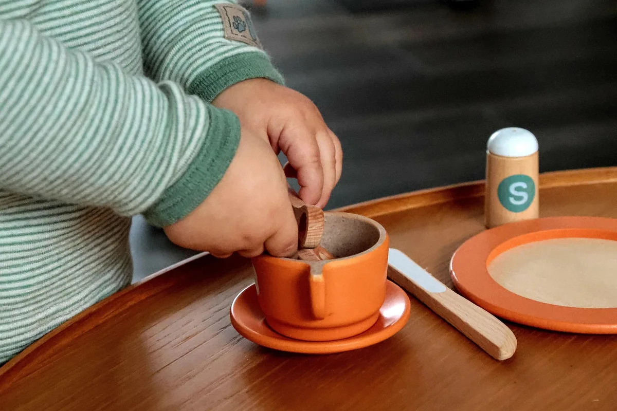 Enfant réparant un objet cassé sous supervision bienveillante