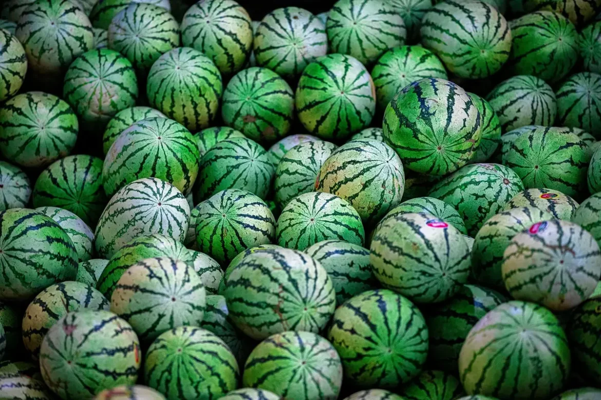Étal de marché asiatique avec paniers de fruits exotiques colorés et une main choisissant un fruit