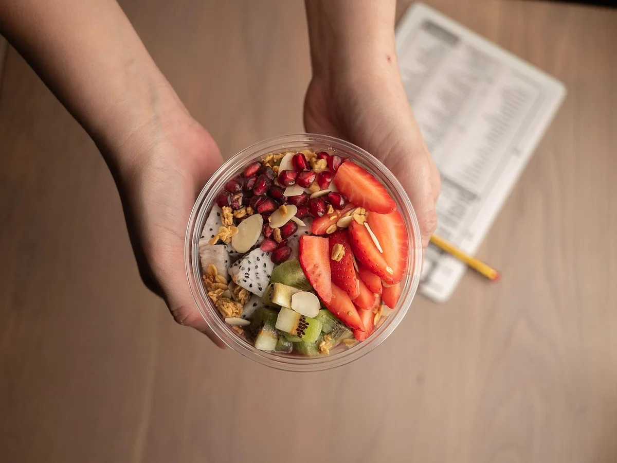 Ingrédients pour smoothie maison : fruit, épinards et eau dans un bol lumineux