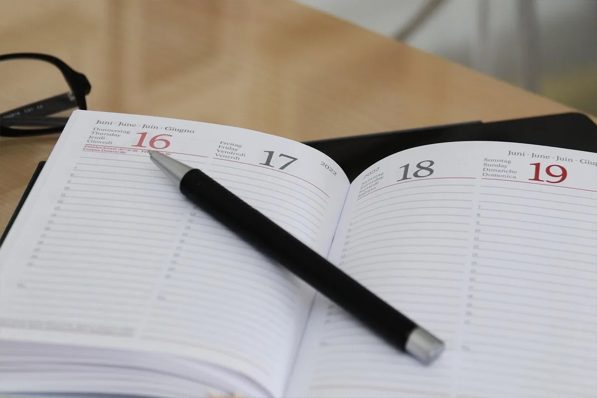 Parents posant un calendrier familial et notant les contraintes avant inscription