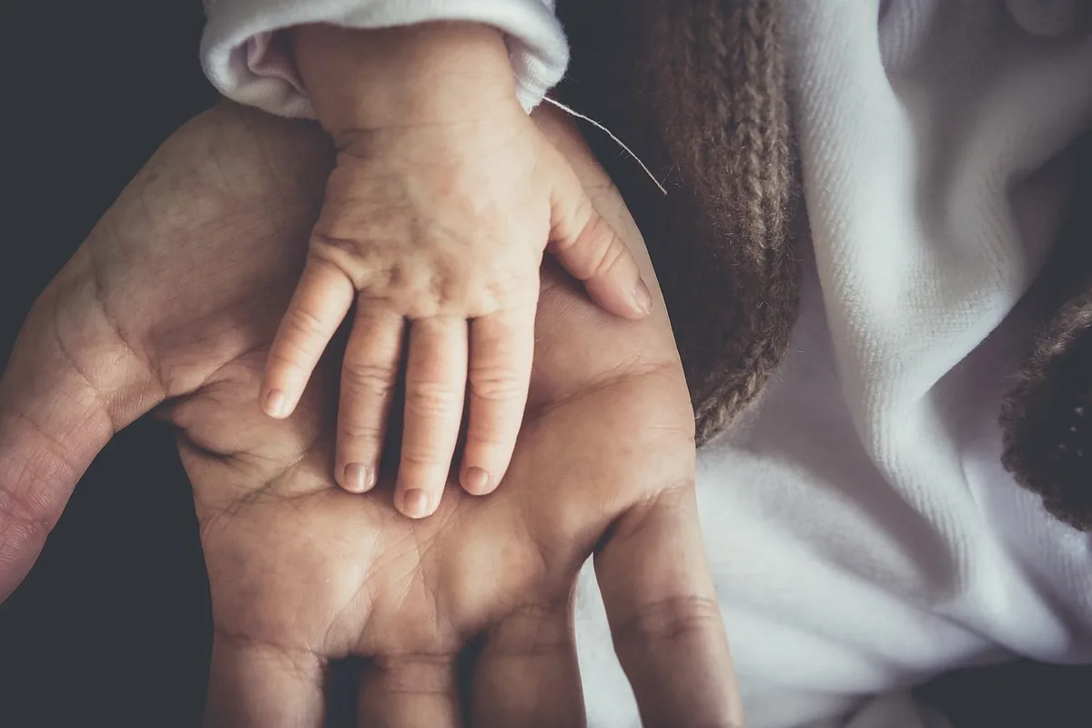 Adulte lisant à voix haute à un enfant dans un coin confortable