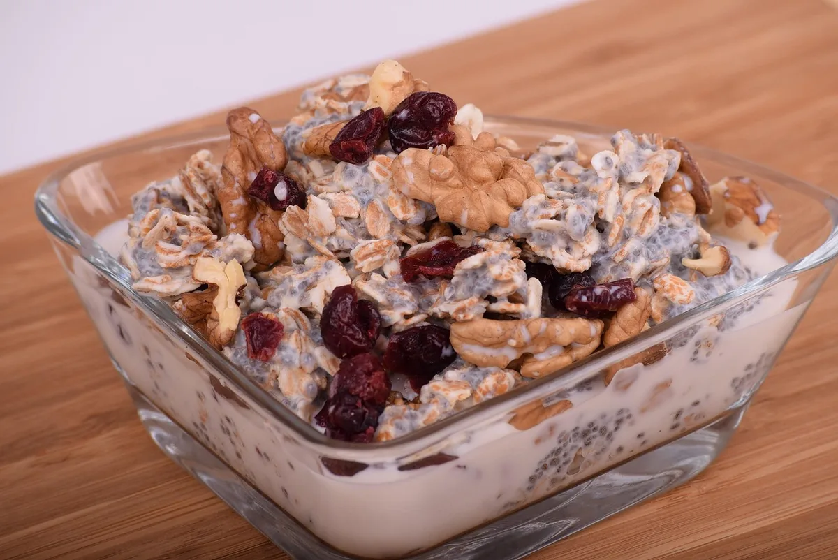 Bol de pudding de chia en cours de préparation avec lait tiède et cuillère
