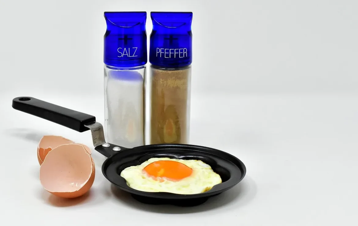 Cuisine en journée : ramequins, poêle et spatule près d'une salade sur un plan de travail lumineux