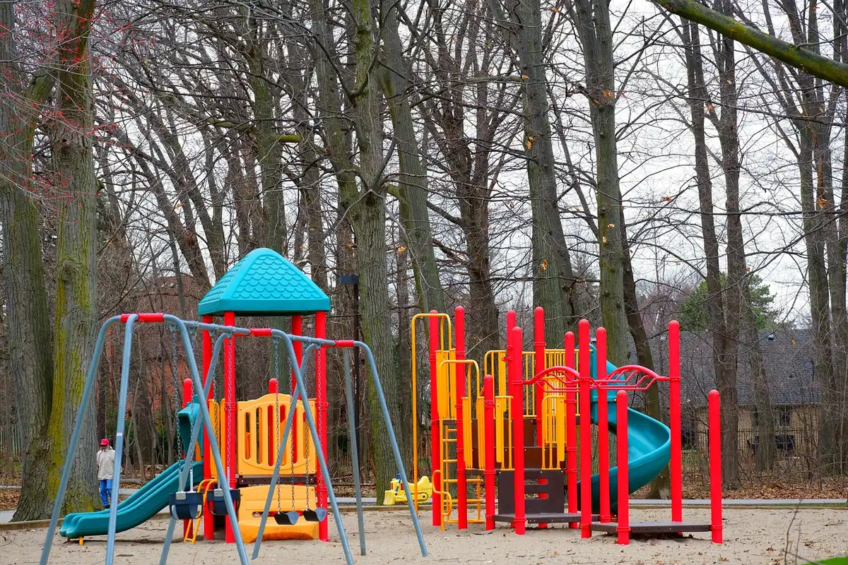 Parents guidant un jeune enfant vers une aire de jeux adaptée