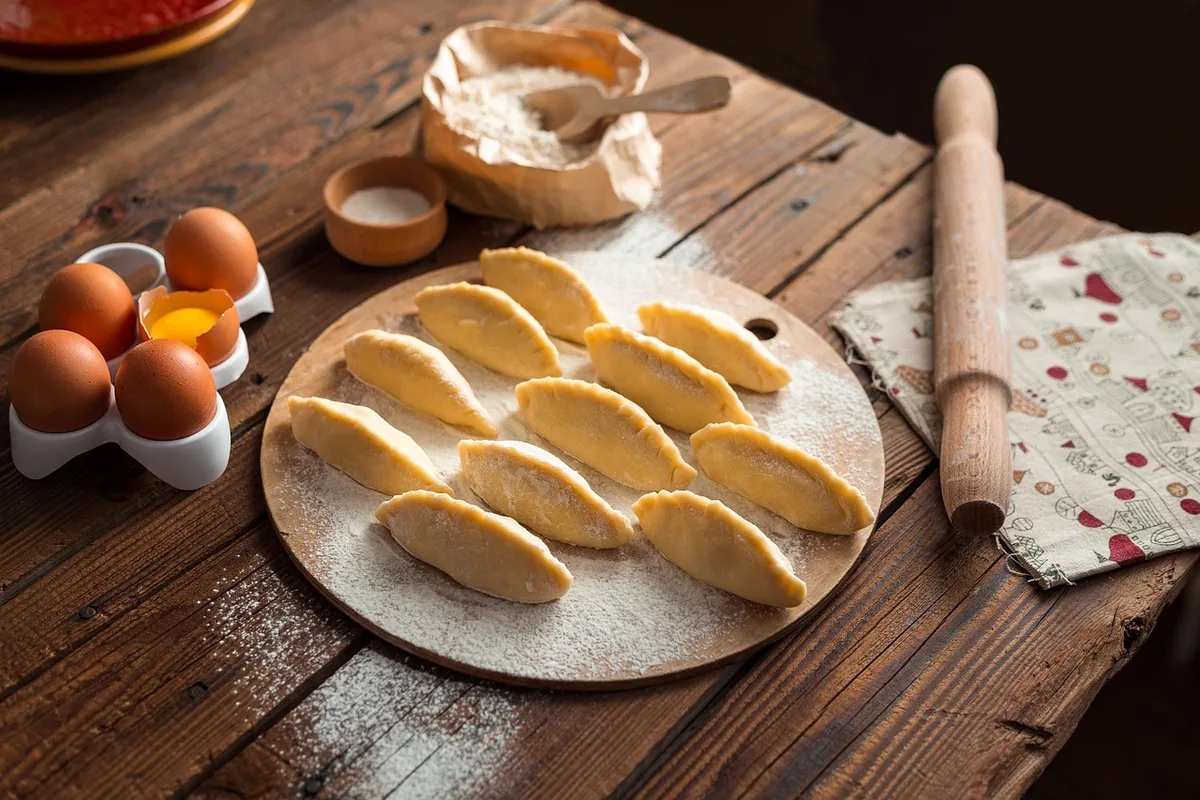 Bol de mayonnaise maison en préparation avec un fouet et des jaunes d'œuf à côté