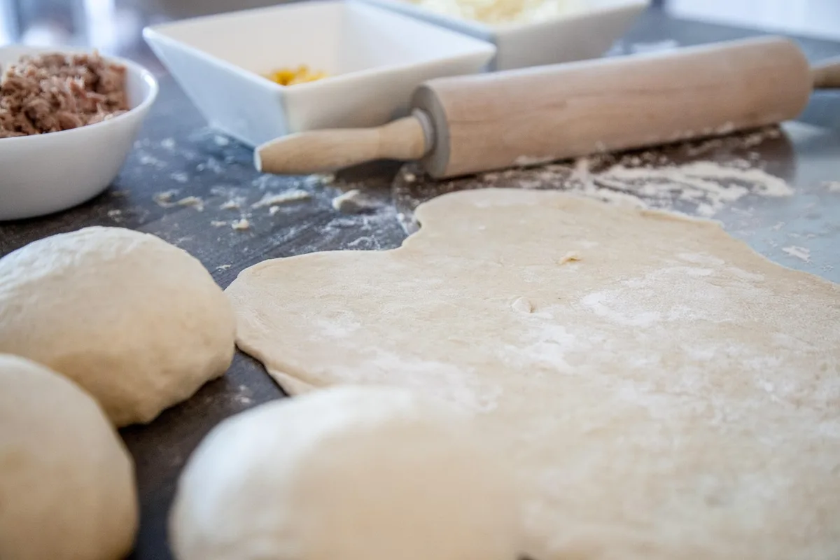 Mains mélangeant une pâte à pizza sans gluten dans un bol