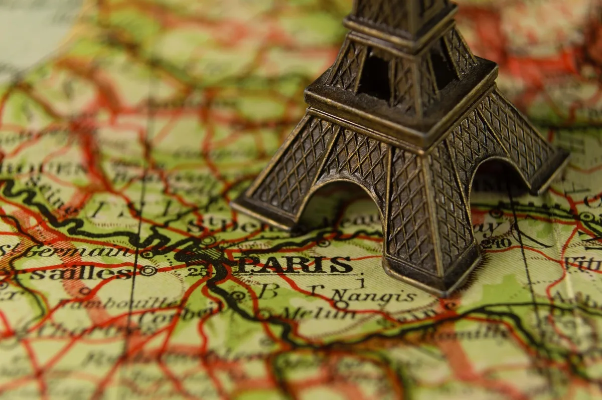 Famille consultant un carnet d'énigmes et une carte lors d'une balade en journée