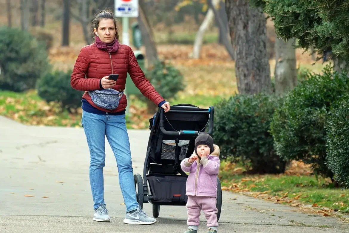 Parents et enfants près d'un banc de parc avec sac et livret, en plein jour