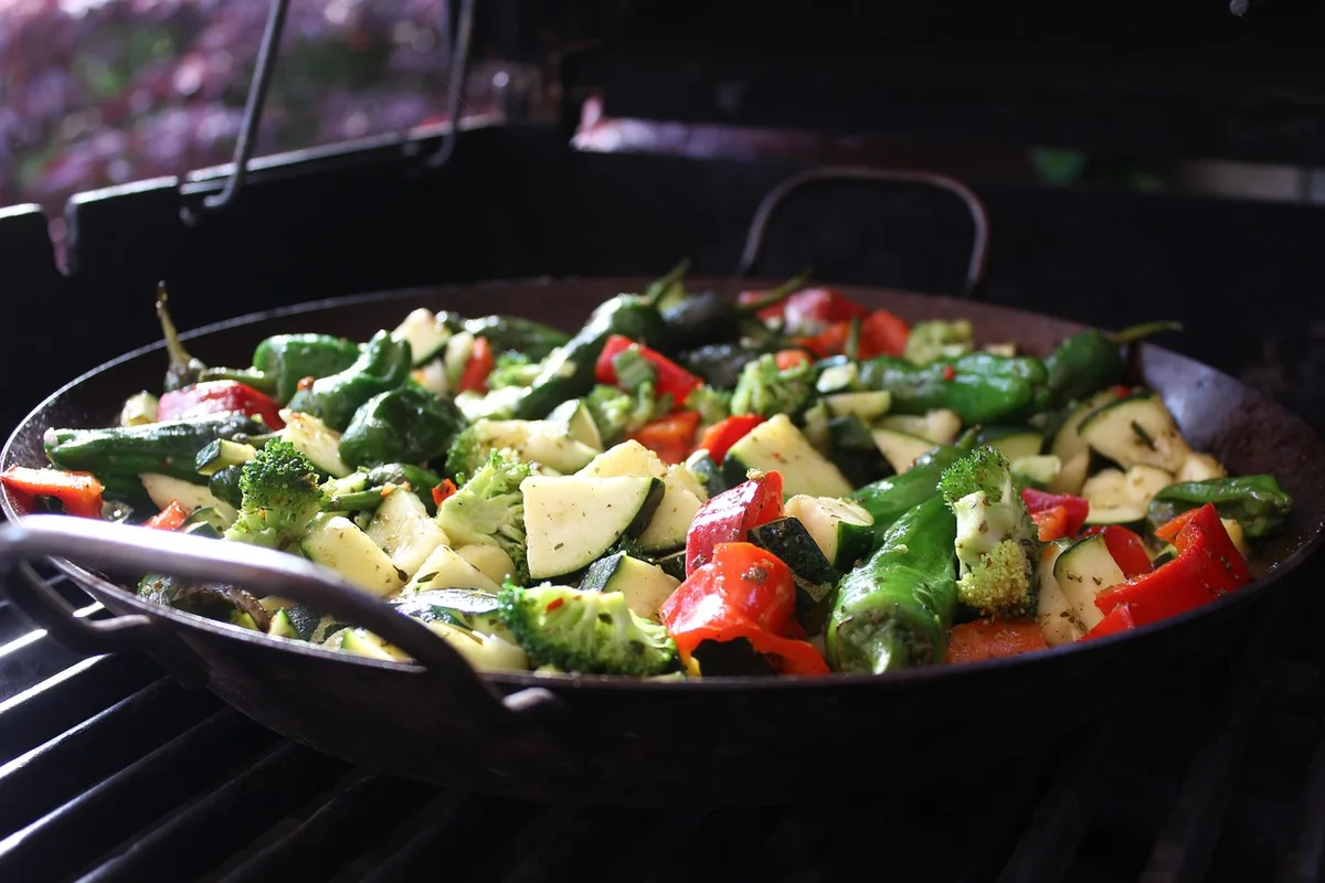 Bocal de confiture de légumes avec cuillère et légumes frais en arrière-plan